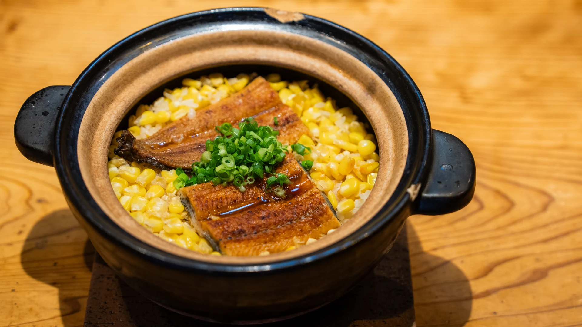 香ばしいうなぎととうもろこしをのせた土鍋ご飯の一例